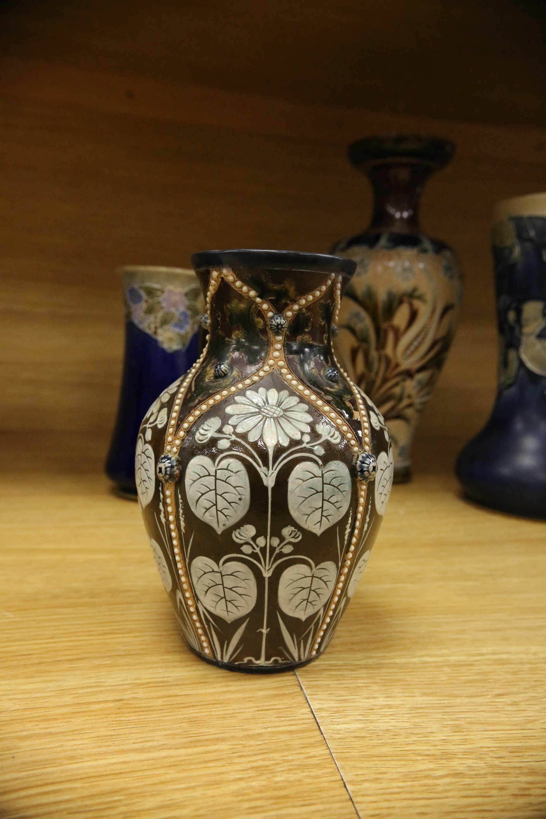 Four Royal Doulton vases and a yellow glazed jug items, tallest vase 34cm high. Condition - some crazing and faults, large vase has damage to lower neck